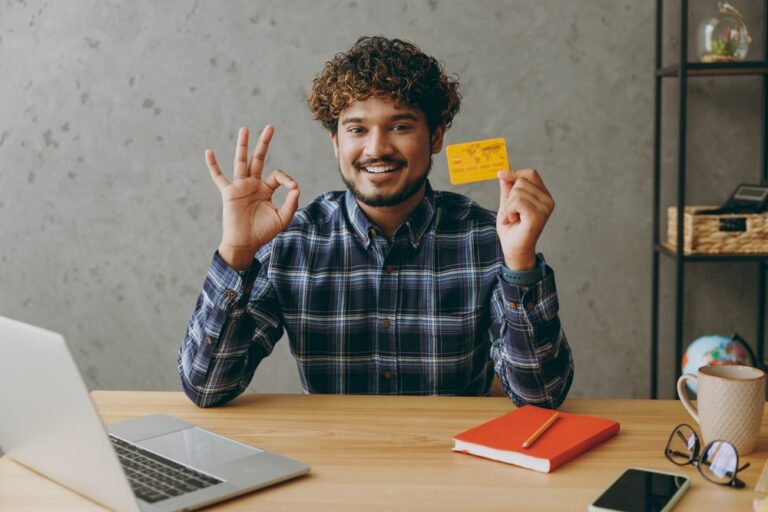 Homem sentado em escritório mostrando seu cartão