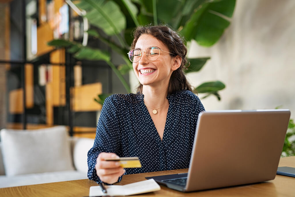 mulher sorrindo com cartão na mão