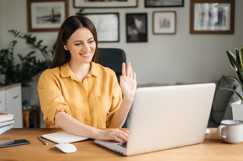 mulher sorrindo sentada em reunião online